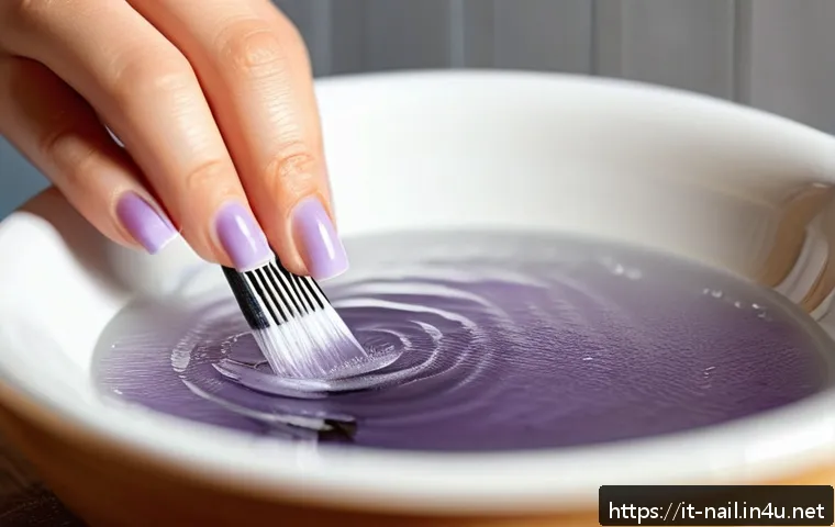 손톱 큐티클 리무버 사용법 - A close-up of a well-manicured female hand soaking in a warm bowl of water, with soft lighting highl...